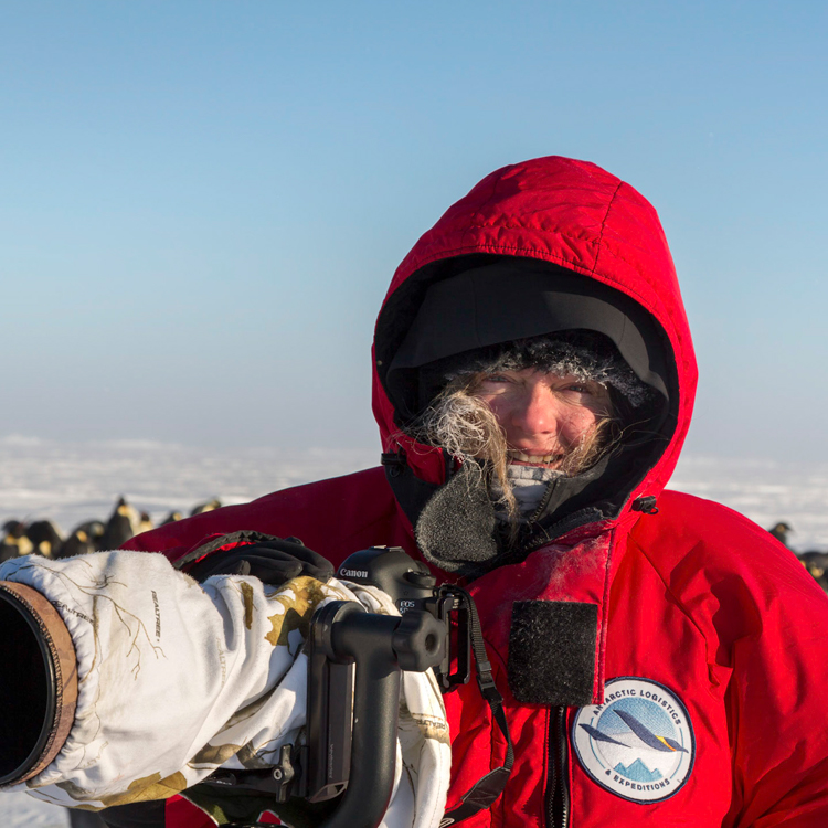 Photographer Sue Flood in a large arctic coat with a long lens camera